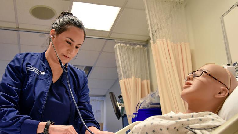 Paola Jaramillo Calderon interacts with a mannequin in Penn State Altoona's nursing simulation lab.